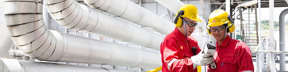 Two engineers having a discussion in the refinery plant.