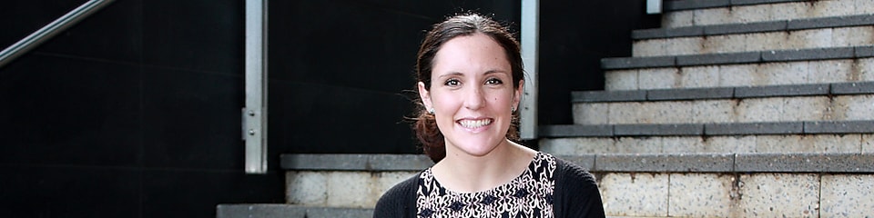 Siobhan Kelly smiles in front of a set of concrete stairs